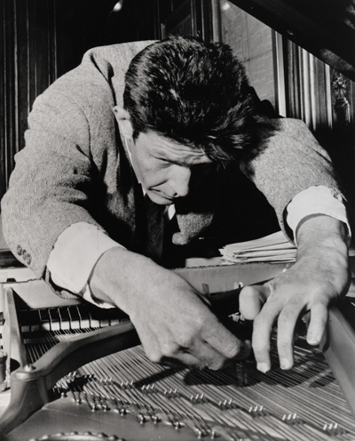 John Cage, afinando su piano o quizá poniendo algodones entre las cuerdas para que no rompa el fascinante silencio con molestas sonatas de Beethoven.